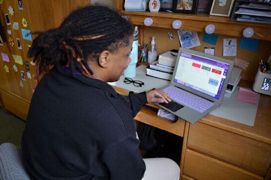 一名女学生在宿舍里用笔记本电脑工作